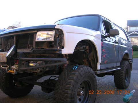 1996 Ford Bronco - This modified Ford Bronco shows off its custom front end with a new white fender and exposed engine components.