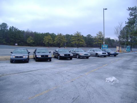 2001 Ford Crown Victoria - Several Ford Crown Victoria police cars are lined up in a parking lot under an overcast sky.