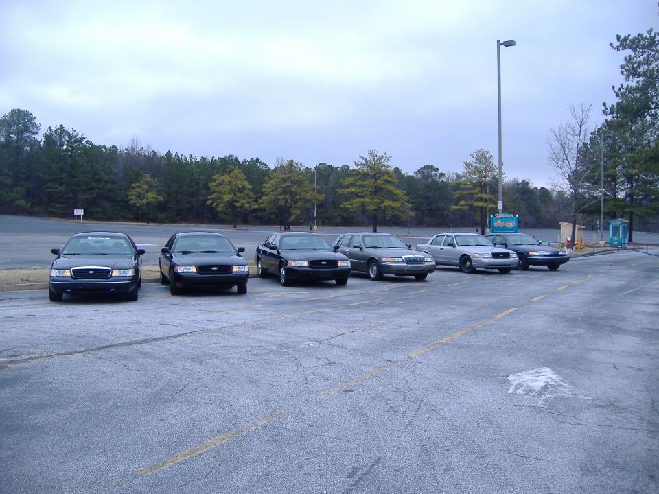Six Ford Crown Victoria police cars parked in a lot