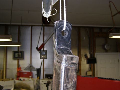 1993 Ford Bronco - A metal bracket, possibly a tow hitch component, is suspended by a rope in a workshop environment.