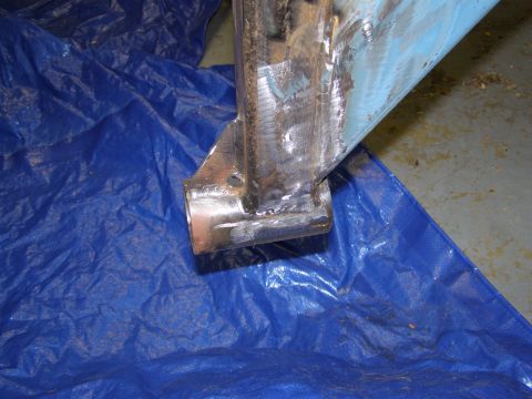 1993 Ford Bronco - Close-up of a welded metal bracket, likely a vehicle part, resting on a blue tarp.