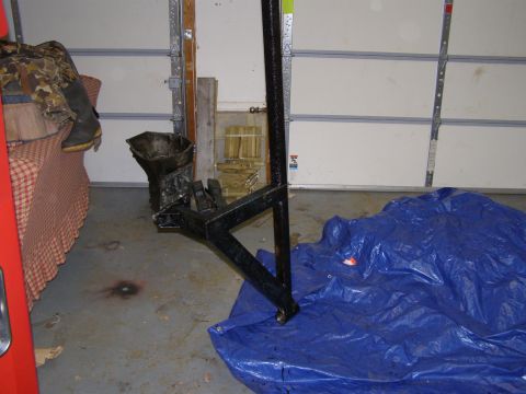 1993 Ford Bronco - A black trailer hitch receiver sits on a blue tarp in a garage, next to a couch and some camouflage gear.