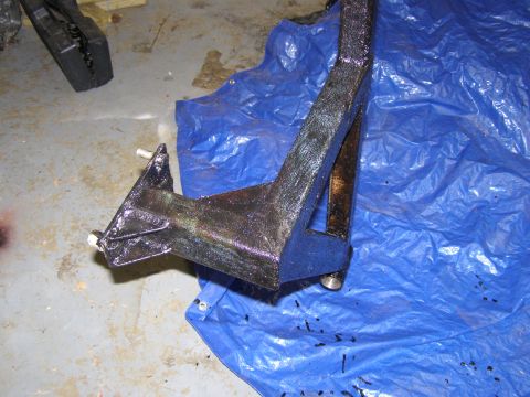 1993 Ford Bronco - A partially covered vehicle part, possibly a tire and suspension, lies under a blue tarp.