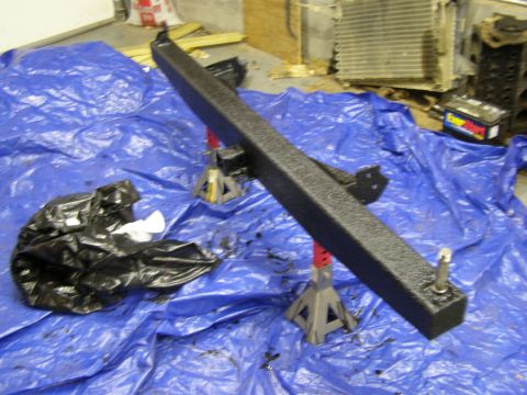 1993 Ford Bronco - A black rear bumper and trailer hitch assembly is displayed on a blue tarp, likely for a vehicle part replacement or sale.