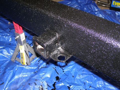 1993 Ford Bronco - A close-up view of a vehicle's rear bumper, showing a tow hitch and electrical connections.