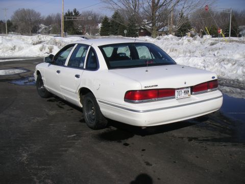 1997 Ford Crown Victoria - A white 1997 Ford Crown Victoria sedan is seen from the rear in an outdoor lot with snow on the ground.