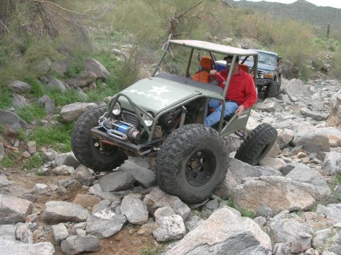 1986 Toyota Hilux - An off-road vehicle is shown traversing a rocky, outdoor environment.