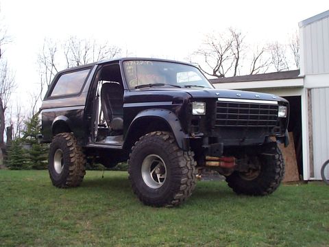 1981 Ford Bronco - This modified Ford Bronco sits on a grassy lawn with a building in the background.