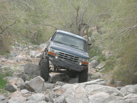 1986 Toyota Hilux - A blue 1992 Ford F-150 navigates a challenging rocky trail, demonstrating its off-road capabilities.