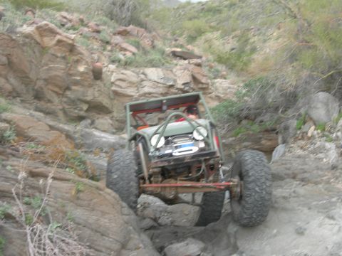 1986 Toyota Hilux - This heavily modified off-road buggy navigates a challenging rocky incline.