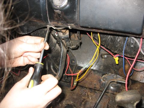 1978 Ford Bronco - Working on the wiring harness near the steering column of a vehicle.