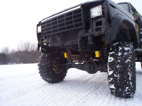 1981 Ford Bronco - This heavily modified truck sits low in the snow, showing off its suspension and large off-road tires.