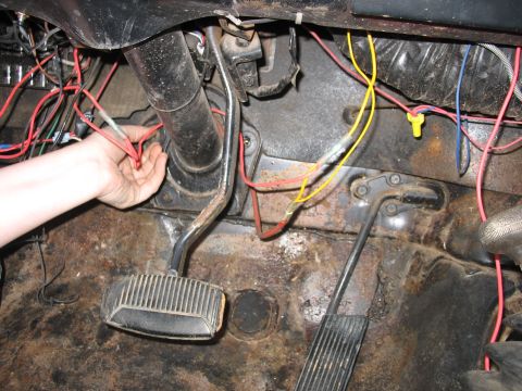1978 Ford Bronco - Close-up of a vehicle's interior showing a steering column, pedals, and exposed wiring.