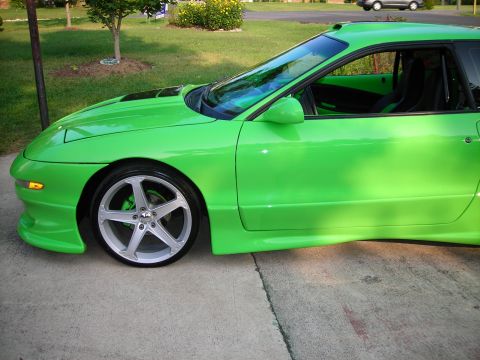 1994 Ford Probe - A bright green 1994 Ford Probe is parked on a concrete driveway with a grassy lawn in the background.
