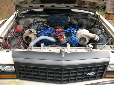 1985 Ford Crown Victoria LTD - The engine bay features a V8 with twin turbochargers and custom blue wiring.