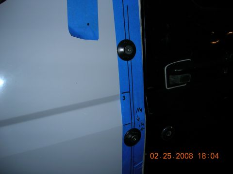 1996 Ford Bronco - Blue tape with measurements and fasteners applied to a vehicle door panel.