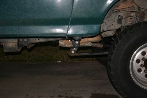 1991 Ford Bronco - Close-up view of the undercarriage and wheel of a green vehicle.