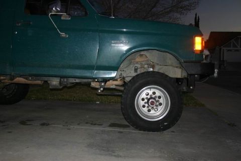1991 Ford Bronco - Side view of a green 1991 Ford Bronco, showing the 'BRONCO' badge on the fender.