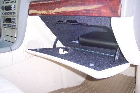 2001 Ford Crown Victoria - The interior of a car is shown with the glove compartment open, revealing its contents and surrounding dashboard details.
