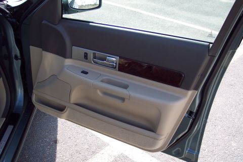 2001 Ford Crown Victoria - The interior door panel features a wood grain accent strip above the armrest and a chrome door handle.