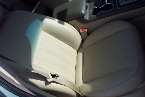 2001 Ford Crown Victoria - Interior view of a car seat and center console with cup holders.