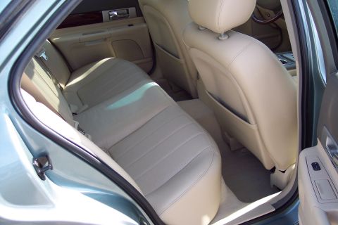 2001 Ford Crown Victoria - The interior of a car is visible, with a focus on the rear seating area and door trim.