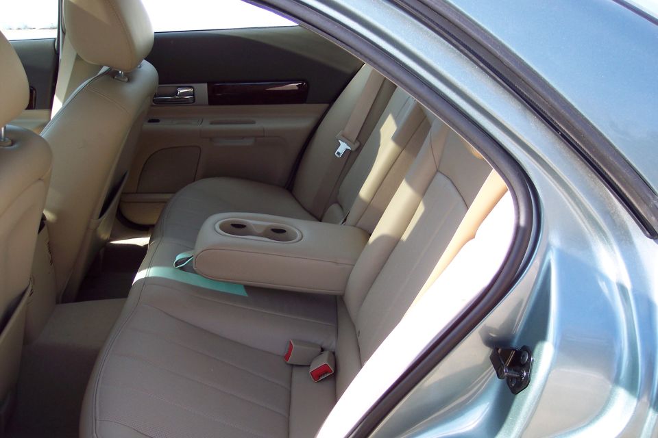 Interior rear seats with beige leather upholstery and cup holders