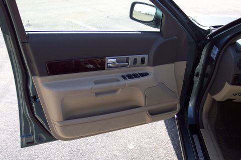2001 Ford Crown Victoria - Interior door panel detail with wood trim and power window controls.