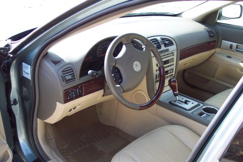 2001 Ford Crown Victoria - The interior of a 2006 Lincoln LS features wood trim accents and a beige leather interior.