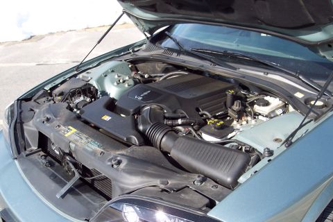 2001 Ford Crown Victoria - The engine bay of a light blue car is shown with the hood open, revealing the V8 engine and associated components.