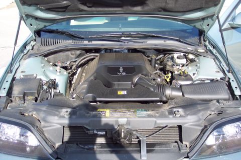 2001 Ford Crown Victoria - The engine bay of a light blue Lincoln LS, a V8 engine cover.
