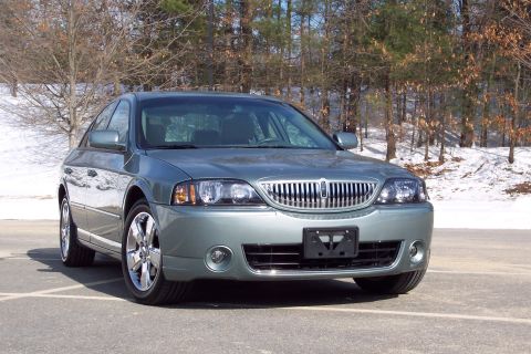 2001 Ford Crown Victoria - A gray 2006 Lincoln LS sedan is shown from the front-left in a parking lot with trees and snow in the background.