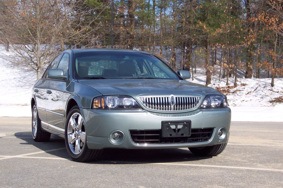 Gray 2006 Lincoln LS sedan parked on asphalt with snow-dusted trees in the background
