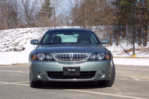 2001 Ford Crown Victoria - Front view of a green sedan, identified as a 2001 model based on its grille design.