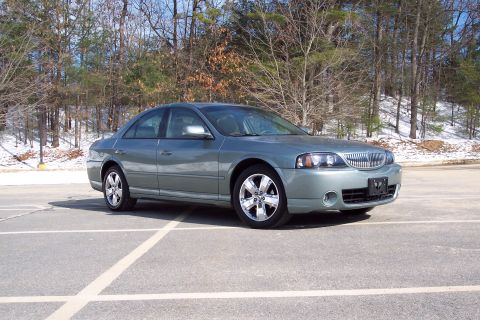 2001 Ford Crown Victoria - A gray 2006 Lincoln LS sedan is parked in an outdoor lot with trees and snow in the background.