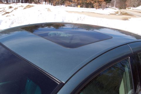 2001 Ford Crown Victoria - The sunroof of a car is visible against a backdrop of snow and trees.