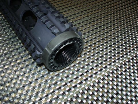 2005 Nissan Titan - A close-up view of a firearm muzzle device, showing the threaded barrel and textured exterior.