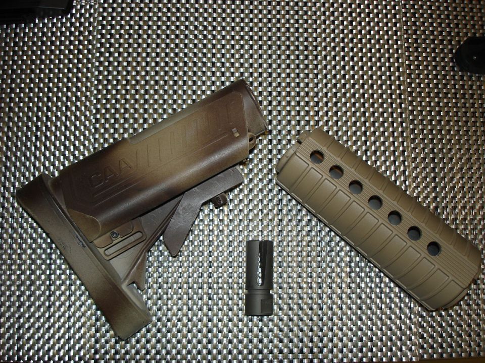 Rifle stock, handguard, and flash hider parts laid on a woven mat