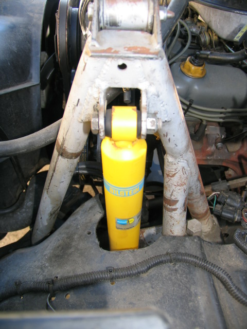 1984 Ford Bronco - Close-up view of the front suspension system, highlighting a yellow Bilstein shock absorber.