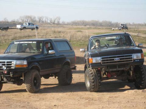 Black Ford Bronco with lifted suspension and large tires, viewed from a 3/4 front angle