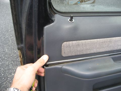 1981 Ford Bronco - Removing the interior door panel to access internal components.
