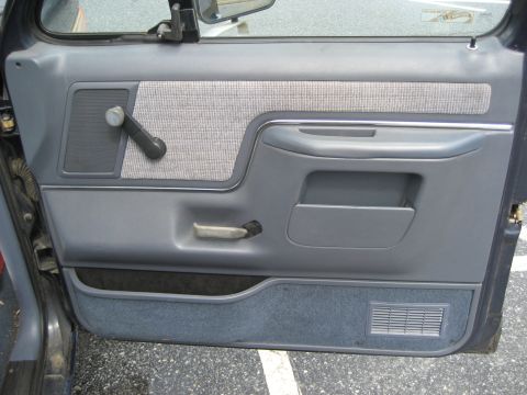 1981 Ford Bronco - Close-up of a truck's interior door panel, showing the fabric insert and armrest area.