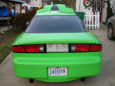 1994 Ford Probe - This modified car features a distinctive spoiler and bright green paint, viewed from the rear.