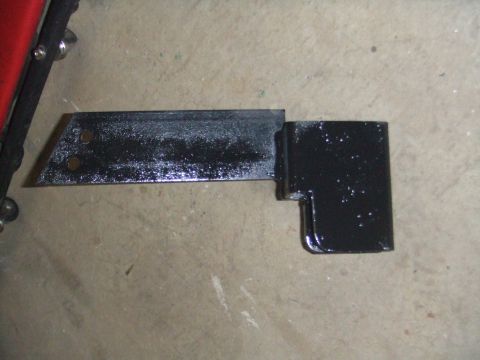 1996 Ford Bronco - A black metal bracket with a beveled edge and a perpendicular section is shown on a concrete surface.