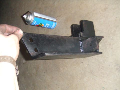 1996 Ford Bronco - Metal bracket and spray can on concrete floor.