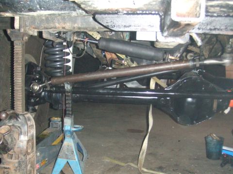 1996 Ford Bronco - The vehicle's undercarriage is supported by jack stands, revealing its suspension and drivetrain components.