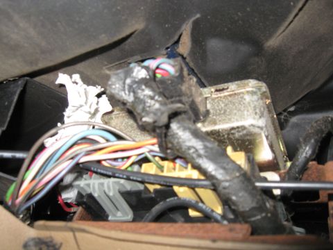 1990 Ford Bronco - Close-up view of a vehicle's interior wiring harness and fuse box.