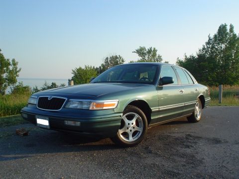 1996 Mercury Grand Marquis - Green 1996 Mercury Grand Marquis parked outdoors with a water background.