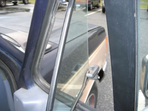 1981 Ford Bronco - The interior of a truck is visible through the open driver's door, with another vehicle in the background.