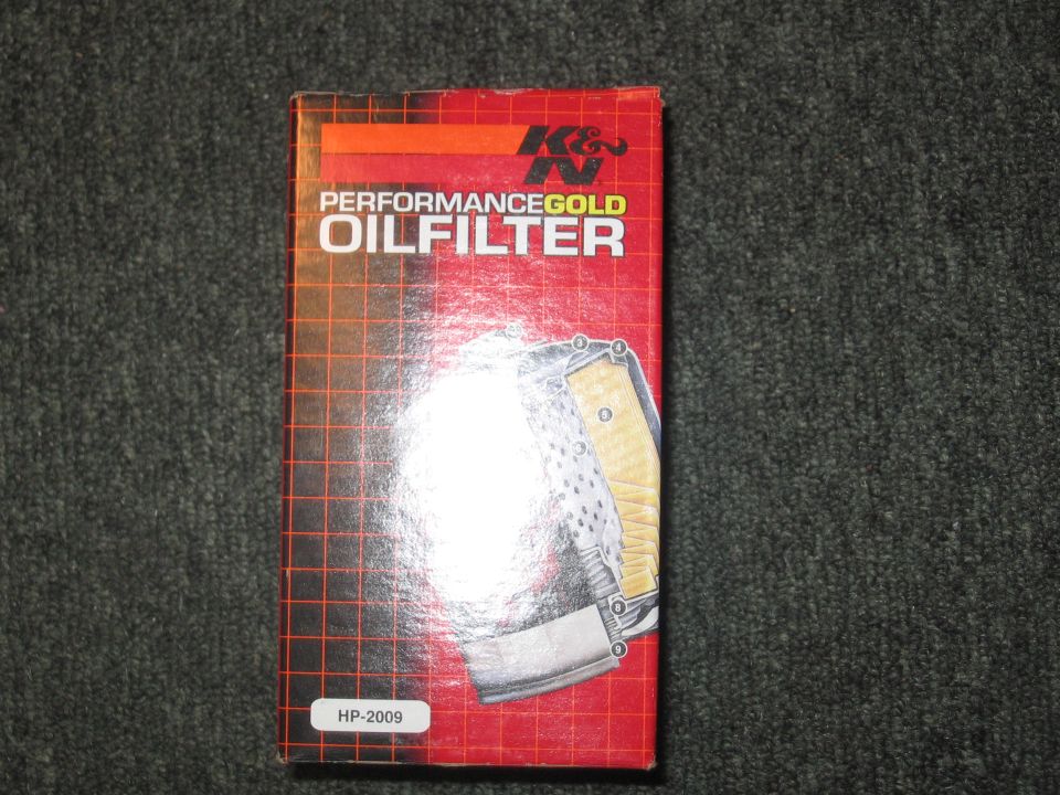 Red and orange box for K&N Performance Gold Oil Filter HP-2009, showing a partial view of the filter inside